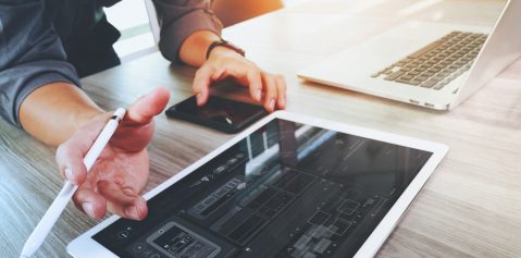 Website designer working digital tablet and computer laptop and digital design diagram on wooden desk as concept